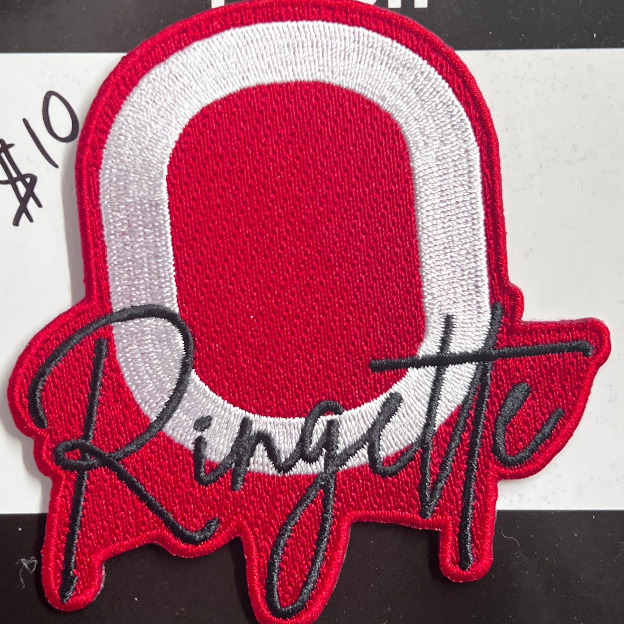 Ringette patch with red and white design on a black background