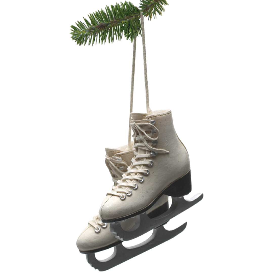 A hand-painted resin ice skate Christmas ornament hanging from a branch.